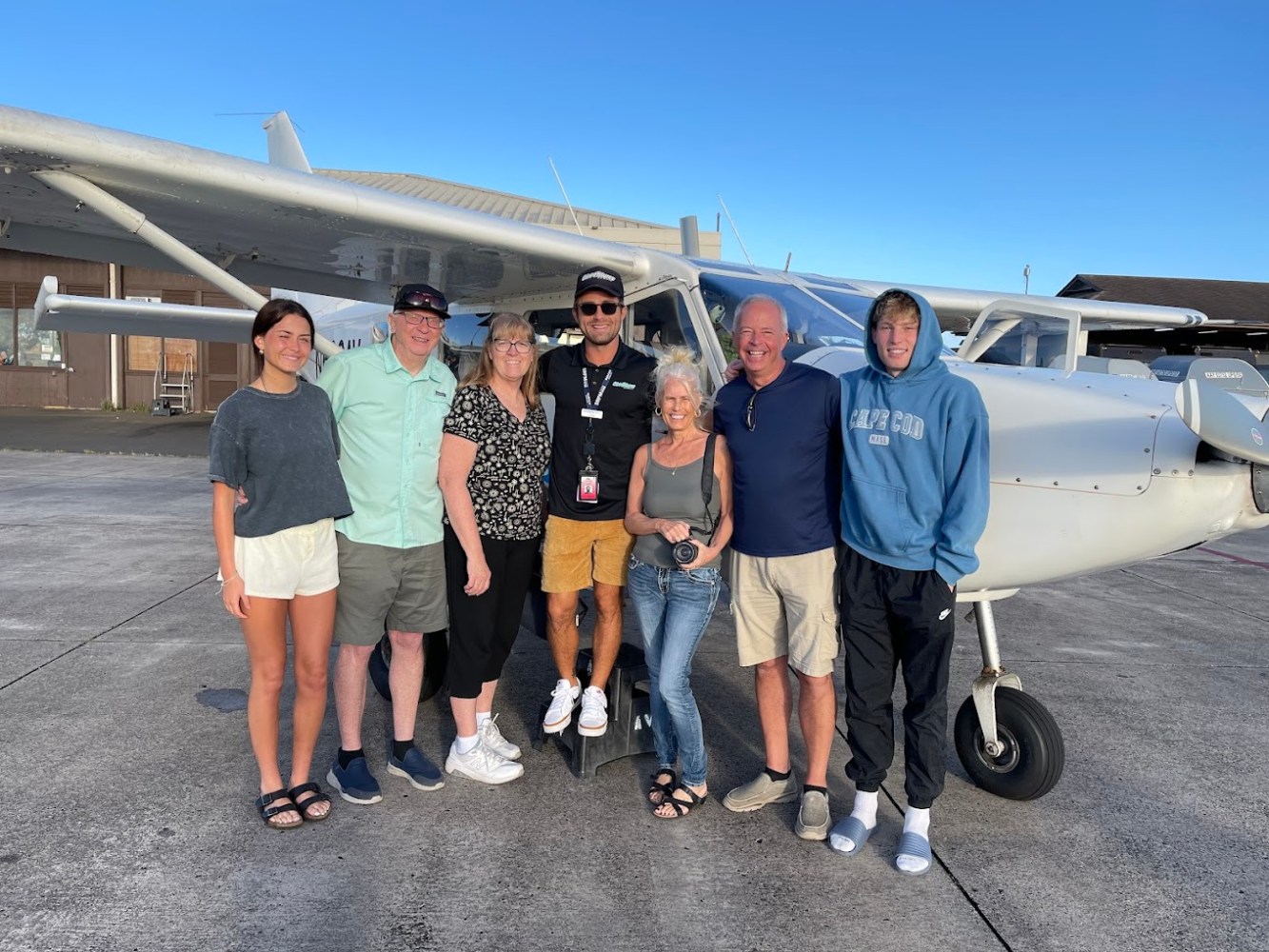 a group of people standing around a plane